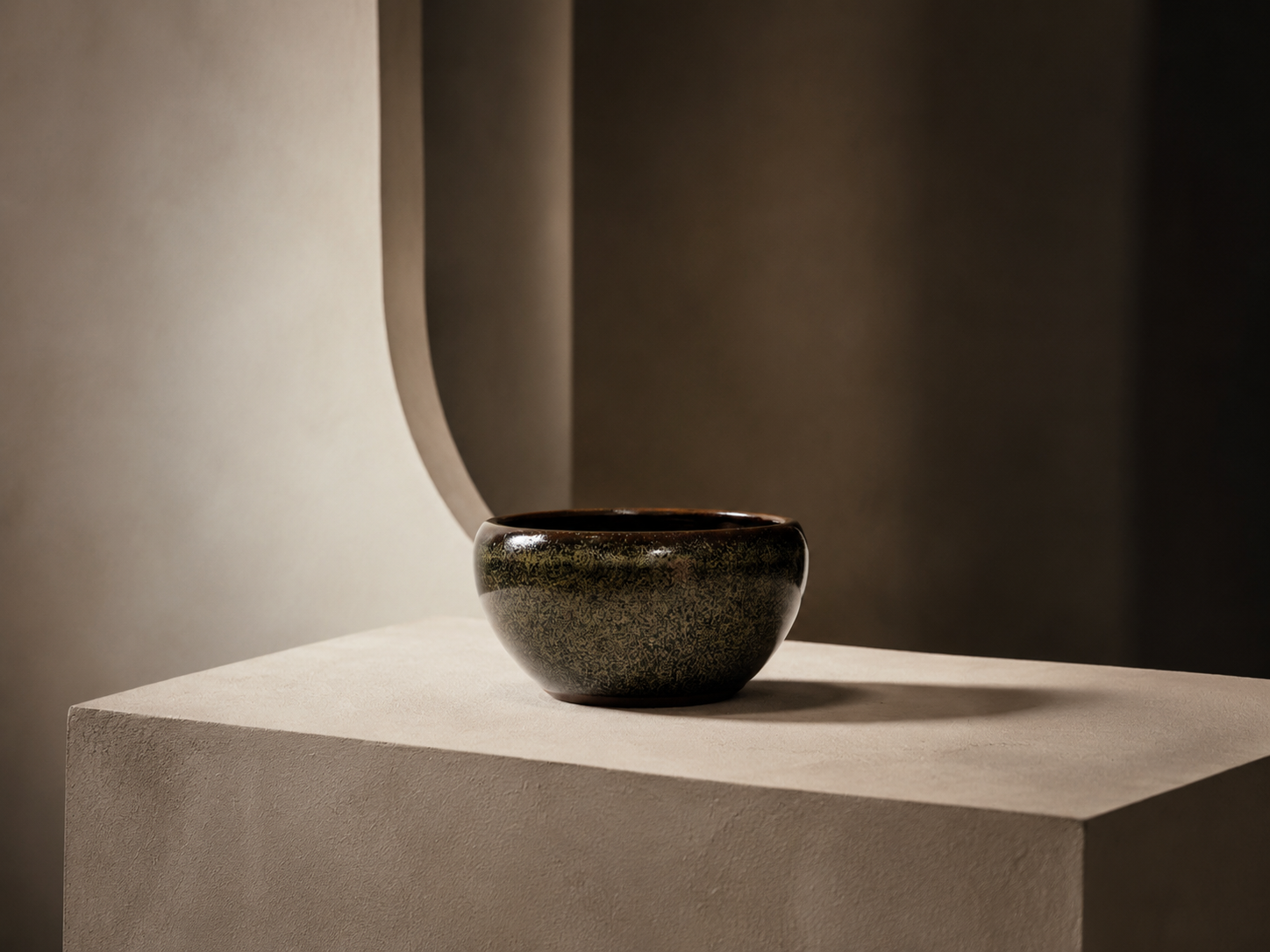Dark ceramic object in an architectural field of warm light