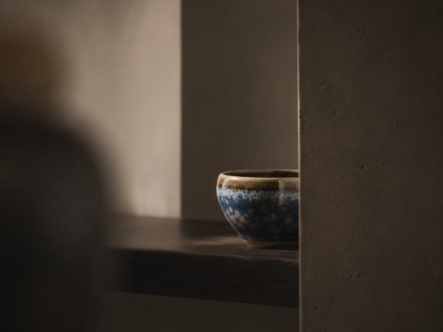 Partial glimpse of a ceramic object between architectural planes